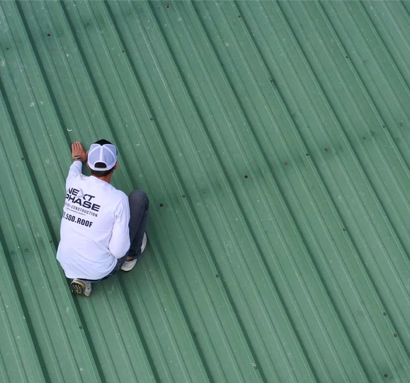commercial-before Blake Catanzano inspecting a metal roof damaged by hail