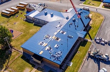 Crane installation of HVAC units and metal roofing at school in Oklahoma