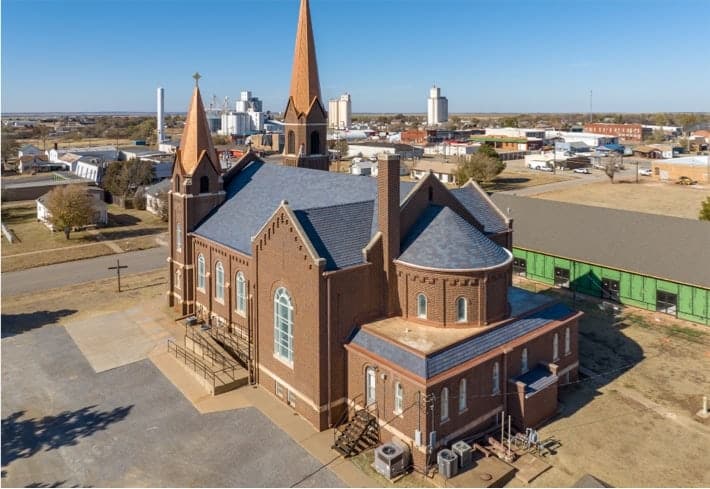 Aerial view of restored Catholic church with DaVinci Slate Tile and copper steeple repair