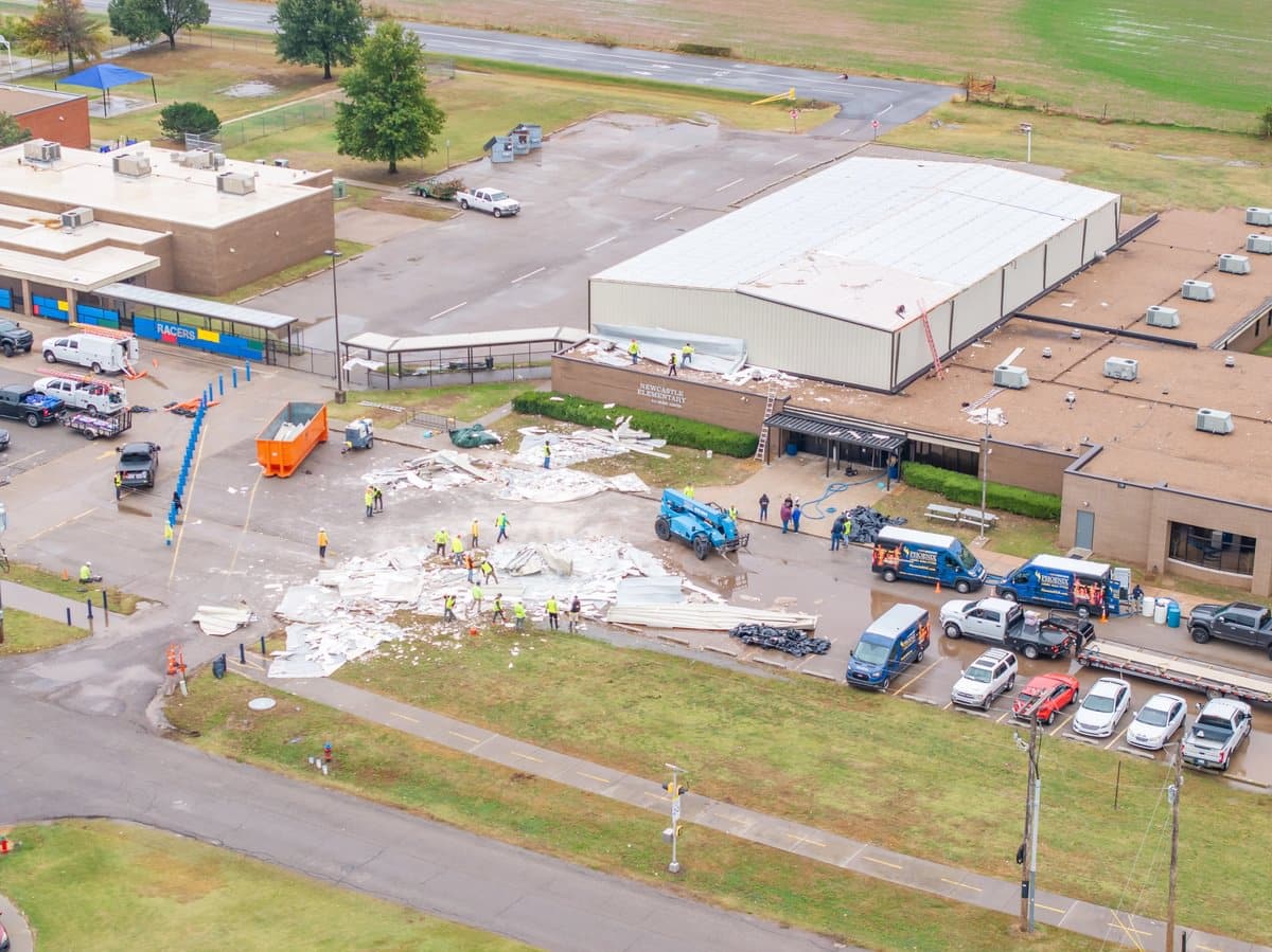 Newcastle Elementary roof damage and debris in parking lot.