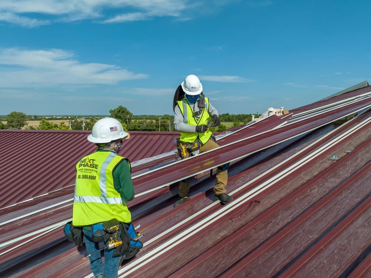 Workers putting together a metal roof.