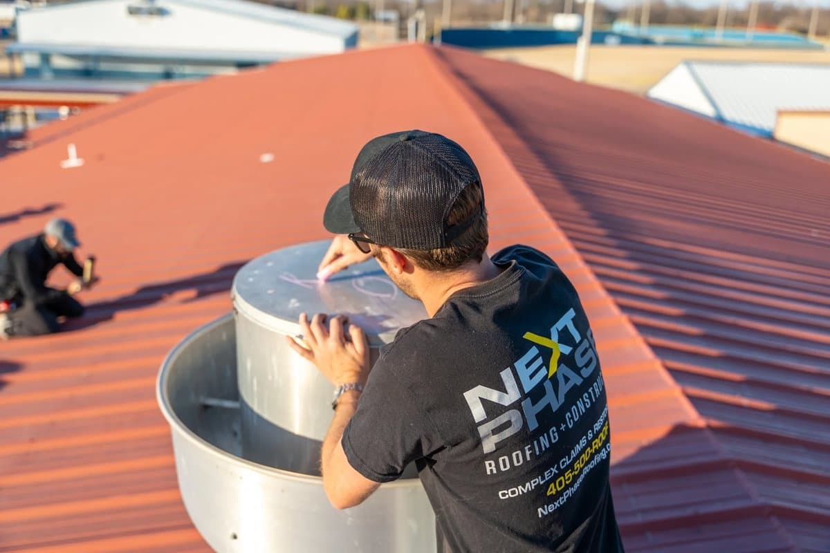 Roofing contractor inspecting the elements of a commercial roof.