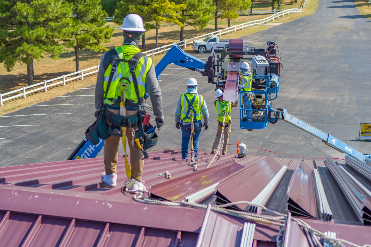Workers using machine to create custom metal roofing panels