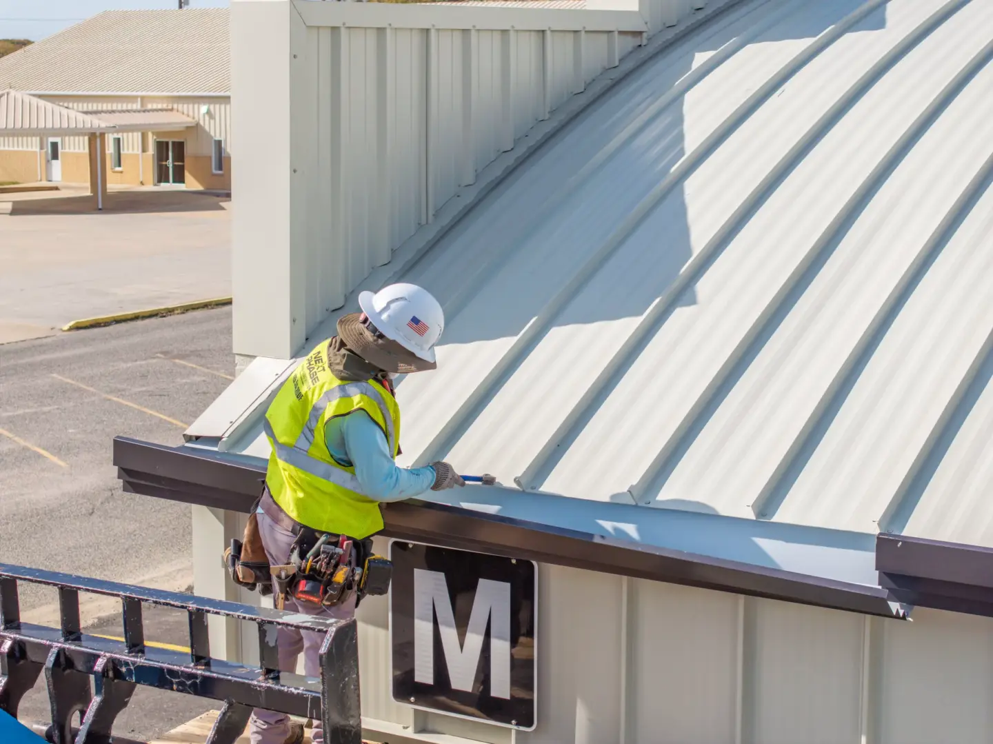 Worker repairing gutters on a metal roof