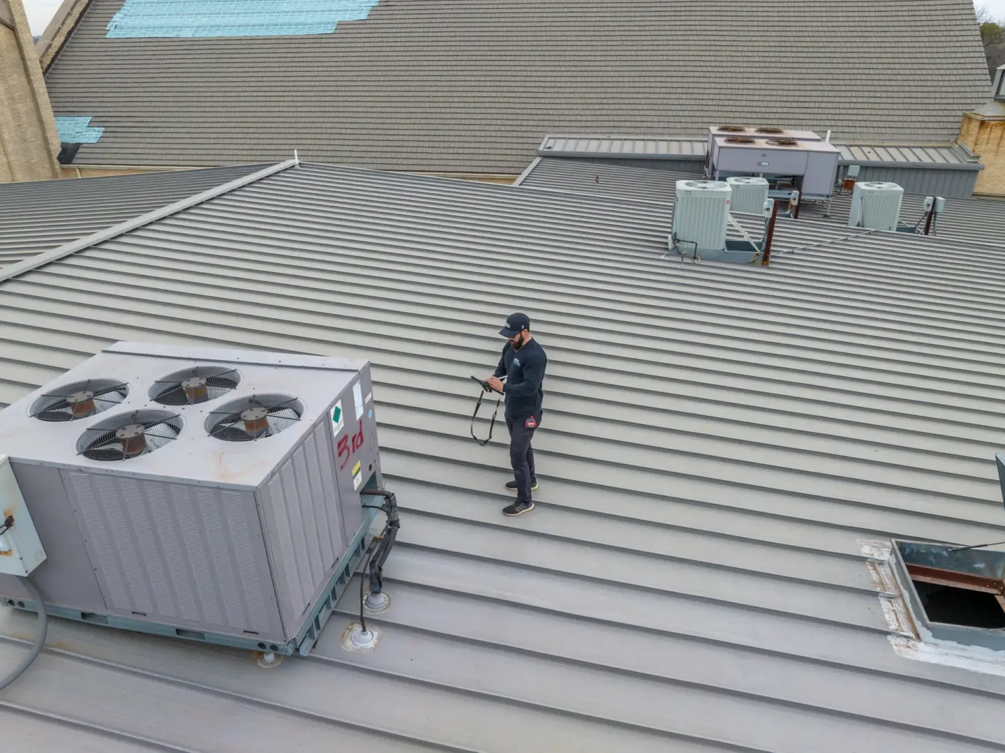 Worker inspecting metal roof