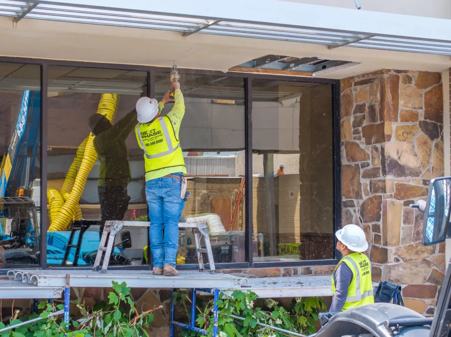 Workers repairing storm damage to a commercial roof