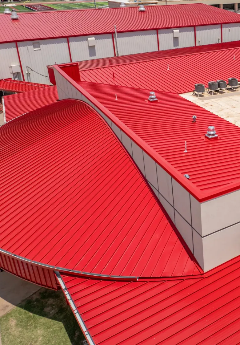 Red standing seam metal roofing installed on multi-building campus